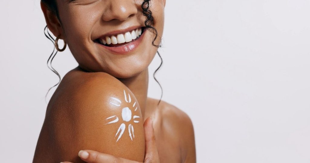 Mujer con protector solar en su hombro